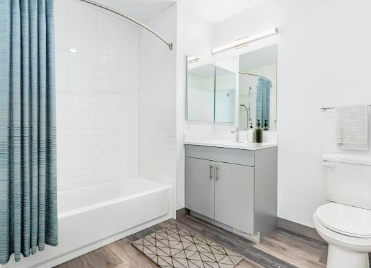 a white bathroom with a shower and a sink