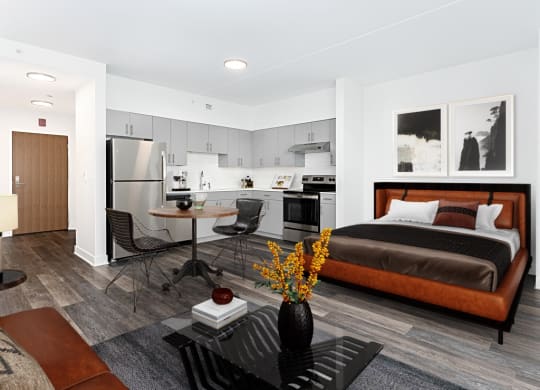 a studio apartment with a bed and a kitchen