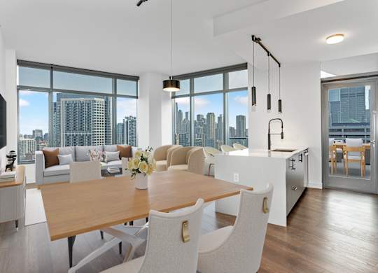 a living and dining room with a city view and a table and chairs at Cassidy on Canal, Chicago