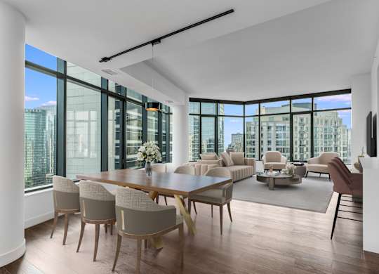 a large living room with a large table and chairs and a view of the city at Cassidy on Canal, Chicago, IL