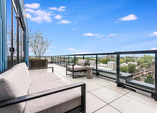 a balcony with a couch and chairs and a view of the city