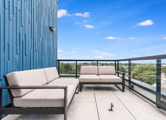 a balcony with two couches and a view of a city