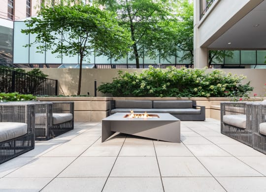 an outdoor patio with a firepit and lounge furniture