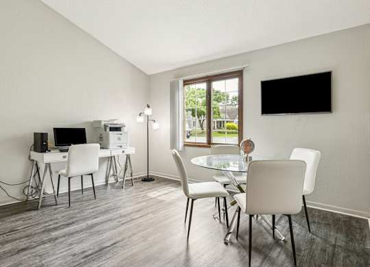 A modern dining room with a glass table and white chairs at Seasons Villas Apartments, Woodbury