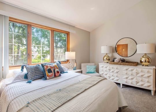 a bedroom with a bed and a large window at Seasons Villas, Woodbury, MN