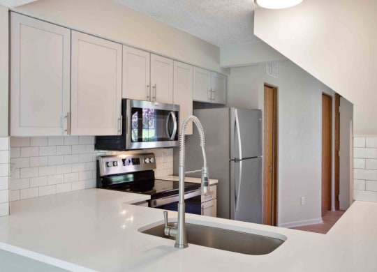 a kitchen with a sink and a refrigerator at Seasons Villas, Woodbury
