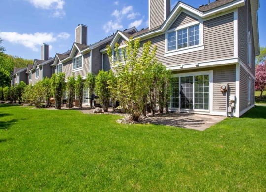 the front of a house with a lawn and trees at Seasons Villas, Woodbury
