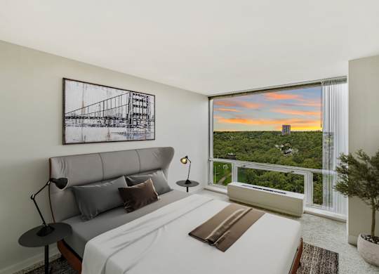 A bedroom with a large bed and a picture on the wall.