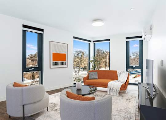 A living room with a grey sofa, orange couch, and a coffee table.