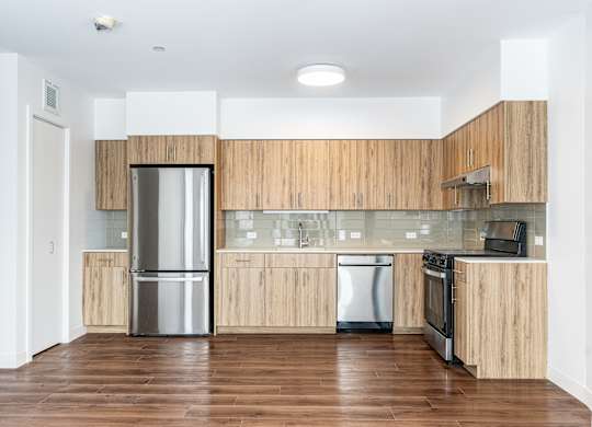 A modern kitchen with wooden cabinets and stainless steel appliances.