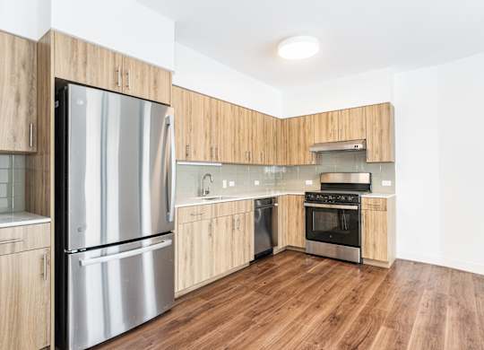 A modern kitchen with wooden cabinets and stainless steel appliances.
