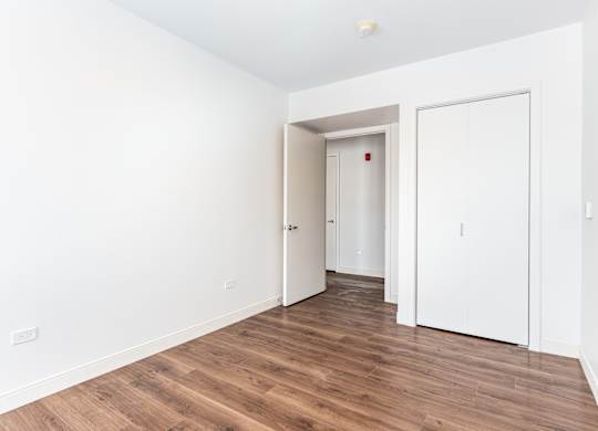 A room with a white door and a white wall.