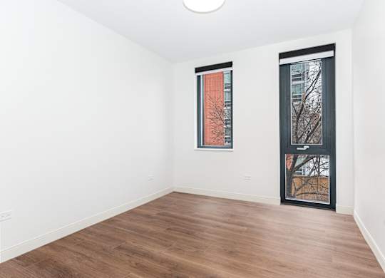 A room with a wooden floor and a picture on the wall.