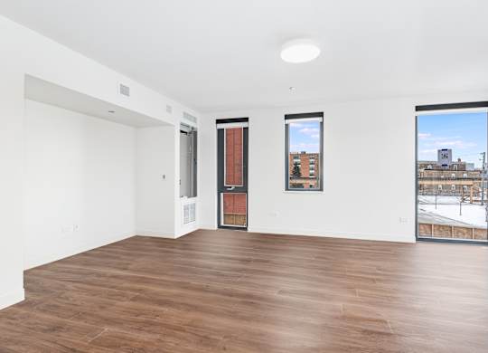 A room with a brown floor and white walls.