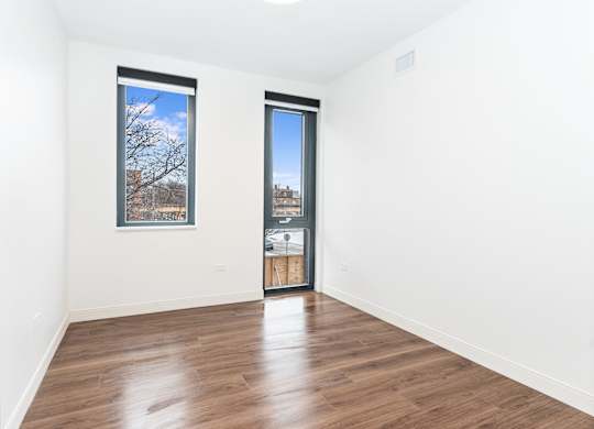 A room with a wooden floor and a picture on the wall.