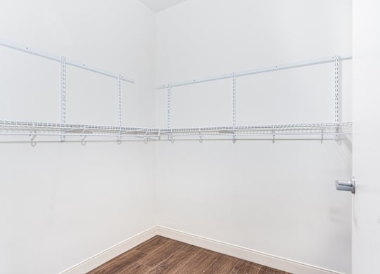 A white wall with a shelf and a door.