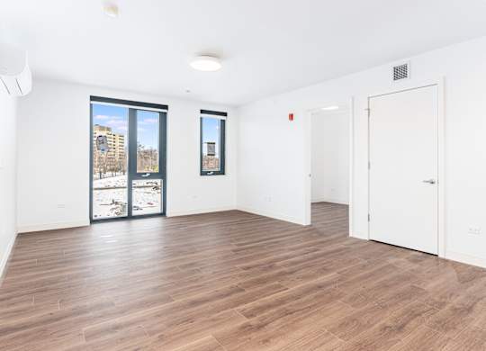 A room with wooden flooring and white walls.