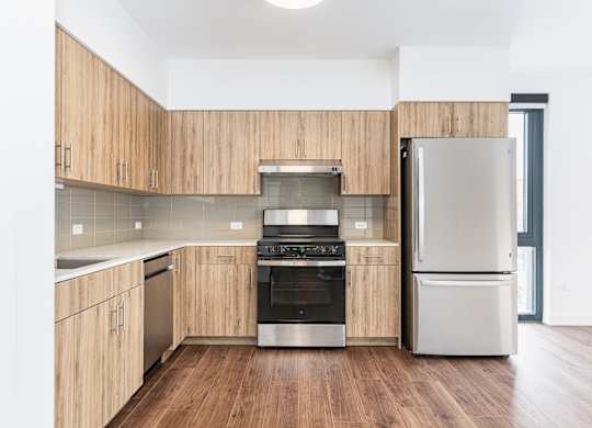 A modern kitchen with wooden cabinets and stainless steel appliances.