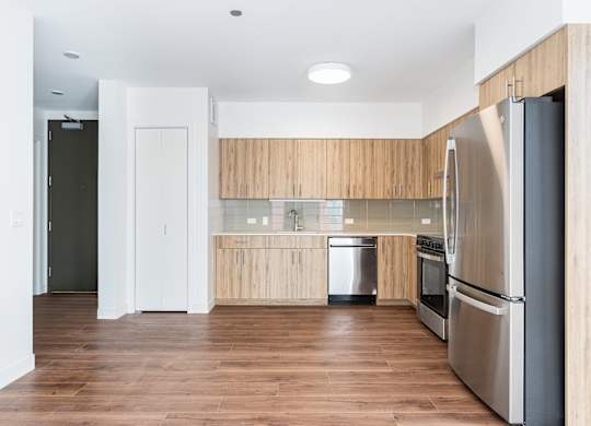 A modern kitchen with wooden cabinets and stainless steel appliances.
