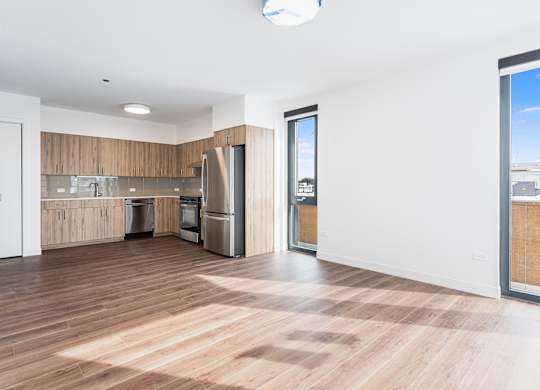 A kitchen with wooden floors and a large window.