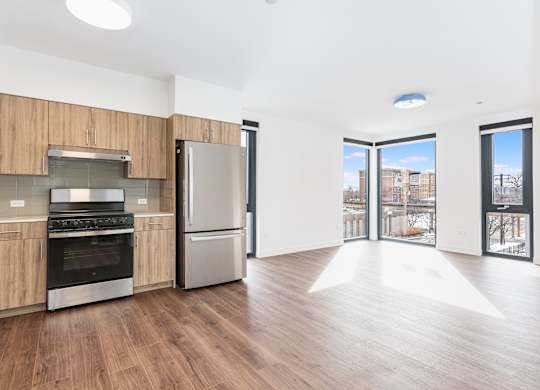 A kitchen with wooden cabinets and a stainless steel refrigerator.