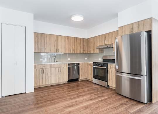 A modern kitchen with wooden cabinets and stainless steel appliances.
