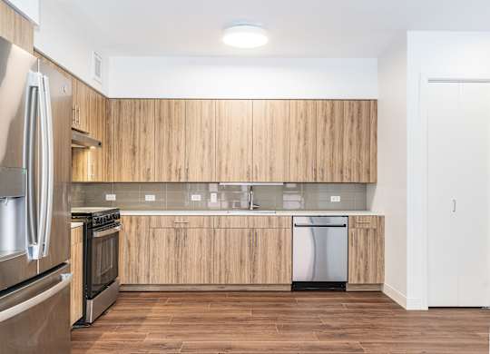 A modern kitchen with wooden cabinets and stainless steel appliances.
