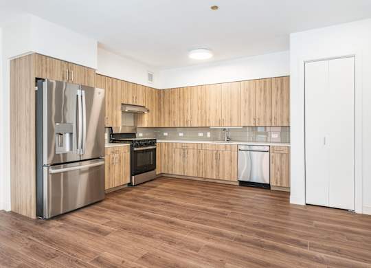 A kitchen with wooden cabinets and a stainless steel refrigerator.