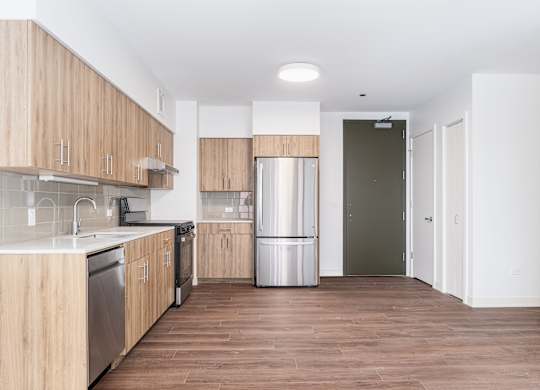 A kitchen with wooden cabinets and a stainless steel dishwasher.
