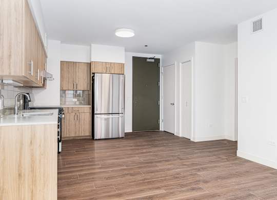 A kitchen with wooden cabinets and a refrigerator.