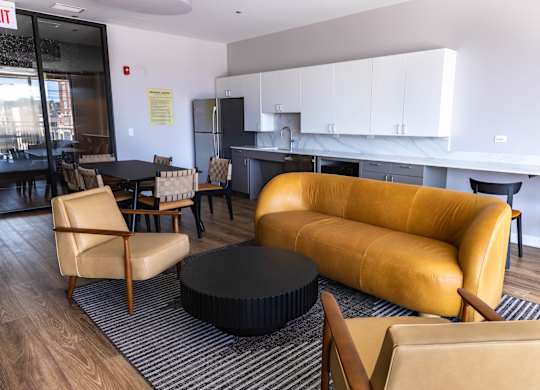 Resident lounge with kitchen and seating area at Thrive Exchange Apartments, Illinois