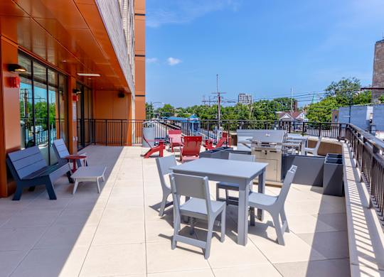 Rooftop terrace with dining tables and colorful seating at Thrive Exchange Apartments, Illinois, 60617