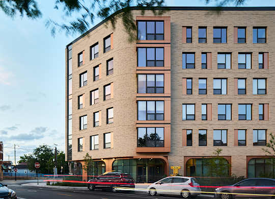 Modern brick building exterior with ground floor retail at Thrive Exchange Apartments, Chicago, 60617