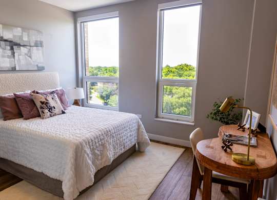 Bedroom with textured headboard and scenic views at Thrive Exchange Apartments, Chicago, IL 60617
