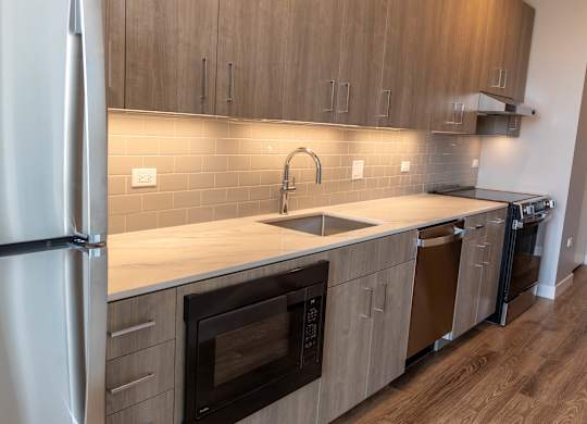 Modern kitchen with under cabinet lighting at Thrive Exchange Apartments, Chicago