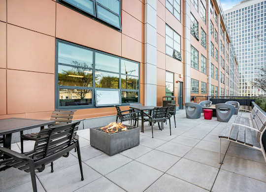 an outdoor patio with tables and chairs and a fire pit at Concord at Sheridan