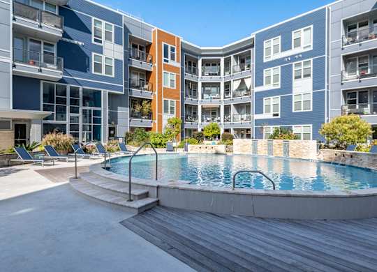 A pool in a courtyard surrounded by apartment buildings.
