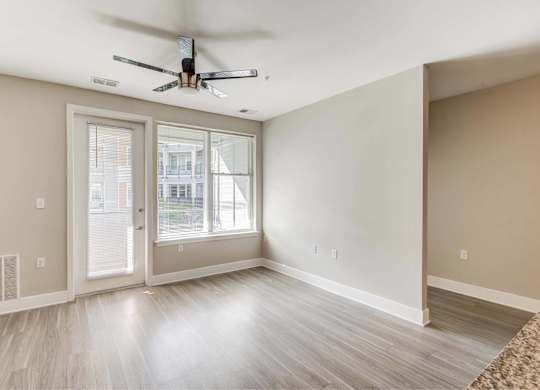 A room with a ceiling fan and a sliding glass door.