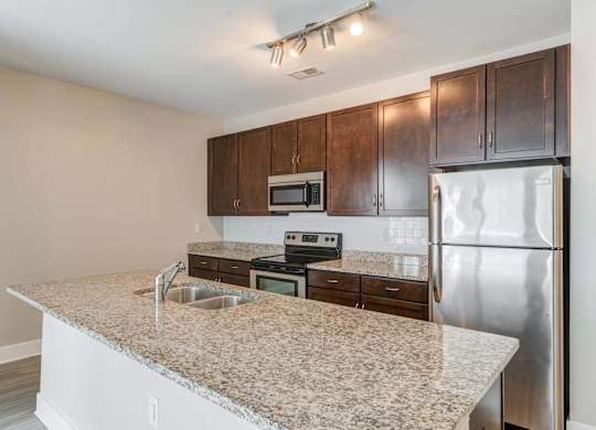 A kitchen with granite countertops and stainless steel appliances.