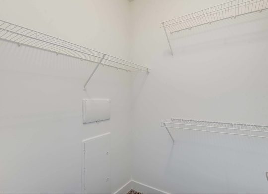 A white wall with a metal rack and a white door.