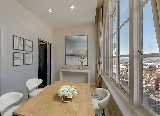 A dining room with a wooden table and chairs.