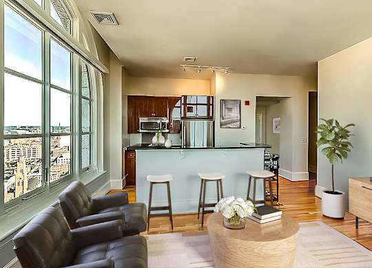 A living room with a bar area and a view of the city.