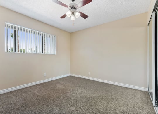 an empty living room with a ceiling fan and a window at Terramonte Apartment Homes, Pomona, CA, 91767