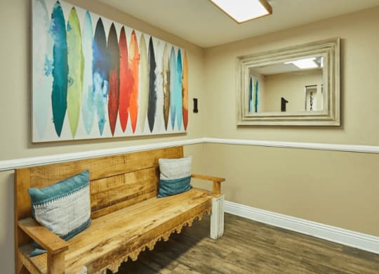 a bench and a painting in a room with a mirror at Huntington Terrace North Senior, Huntington Beach, CA 92648