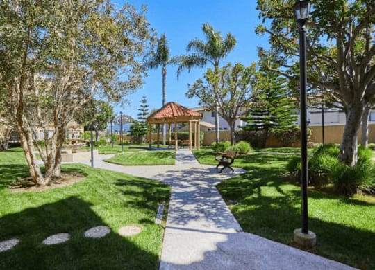 a pathway through a park with a gazebo and trees at Huntington Terrace North Senior, California