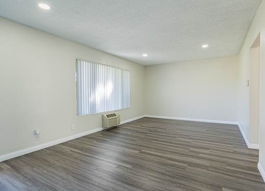 A room with a window and a heater on the floor.