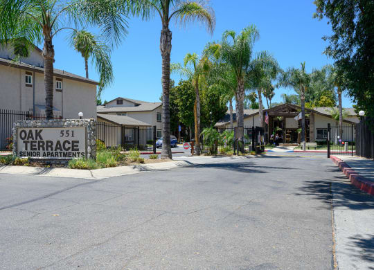 a street with houses on each side and a sign that reads oak 51 terrace at Oak Terrace Senior Apts, Hemet California