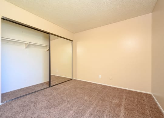 a bedroom with a closet and a window at Oak Terrace Senior Apts, Hemet, 92543