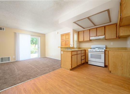 a kitchen and living room with a sliding glass door leading to a patio at Oak Terrace Senior Apts, Hemet California