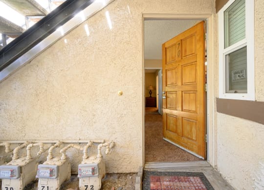 an open door leading to a hallway with a wooden door and white boxes in front of it at Oak Terrace Senior Apts, Hemet California
